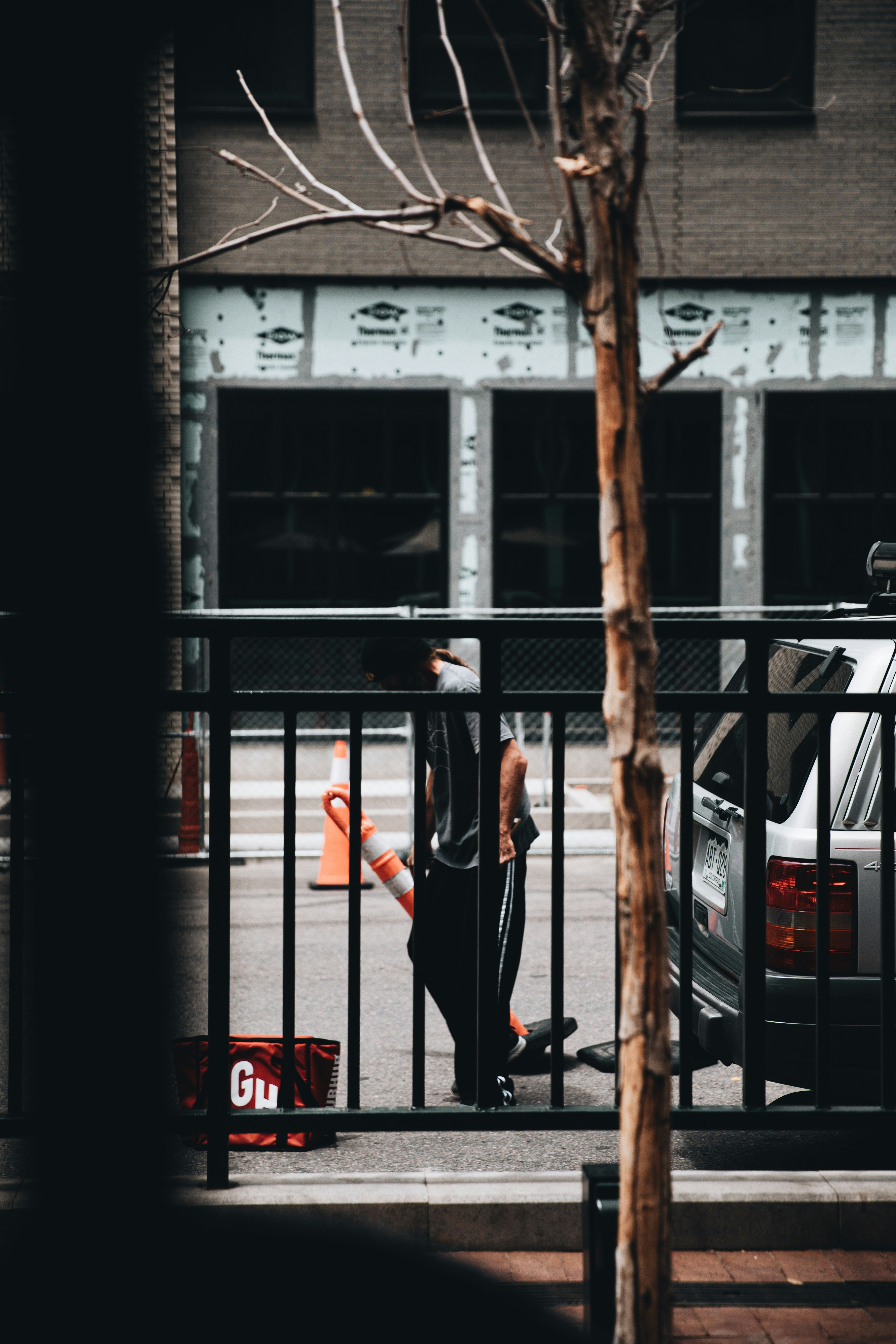 woman in black dress standing beside black metal fence